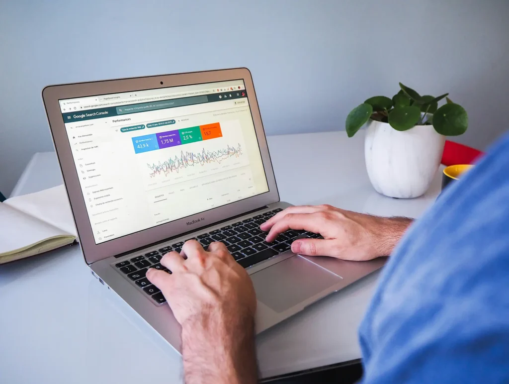 person-die-das-macbook-air-auf-einem-weissen-tisch-benutzt